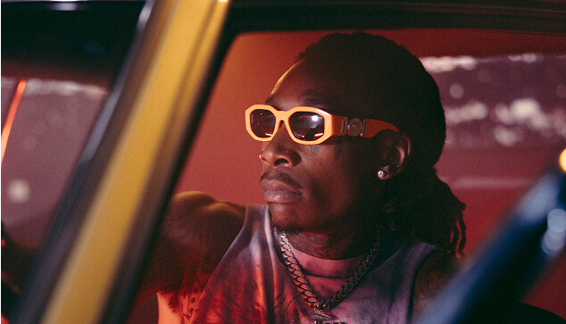 Wiz Khalifa im Auto mit Sonnenbrille.